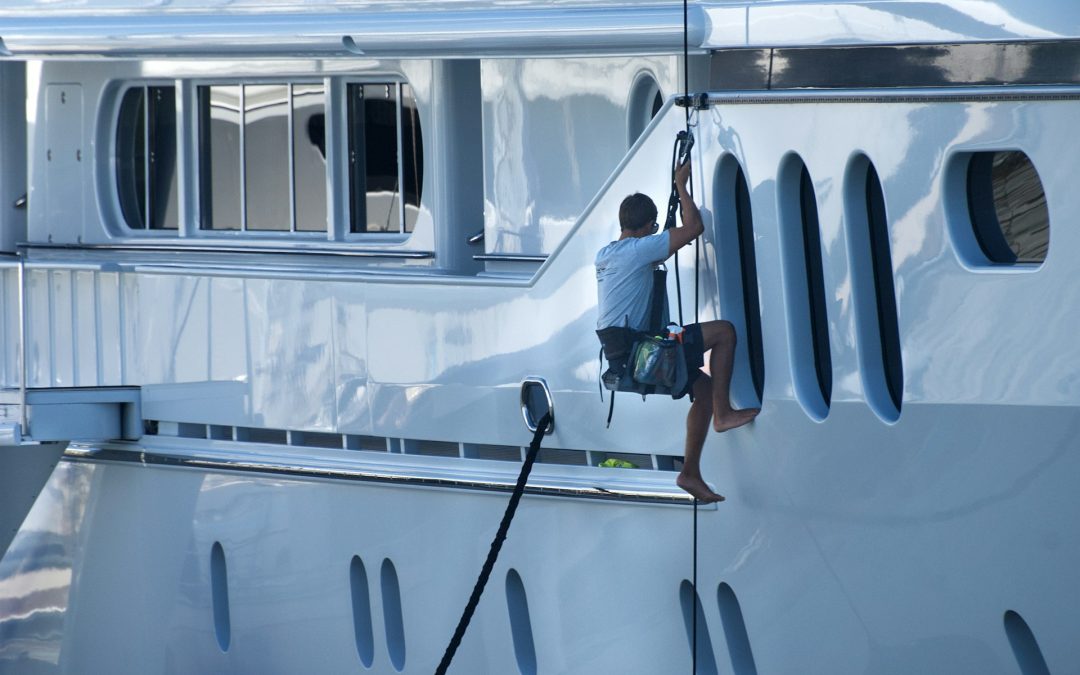 yacht being cleaned by worker